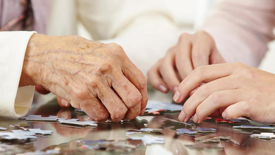 Un anciano realiza un puzzle en una residencia.