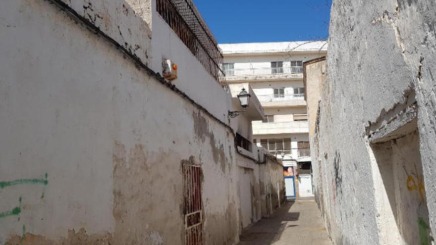 A la izquierda, vivienda y balcón con rejas y almacén, ayer, aún con el rastro del incendio de enero de 2017 en la calle Hierro .