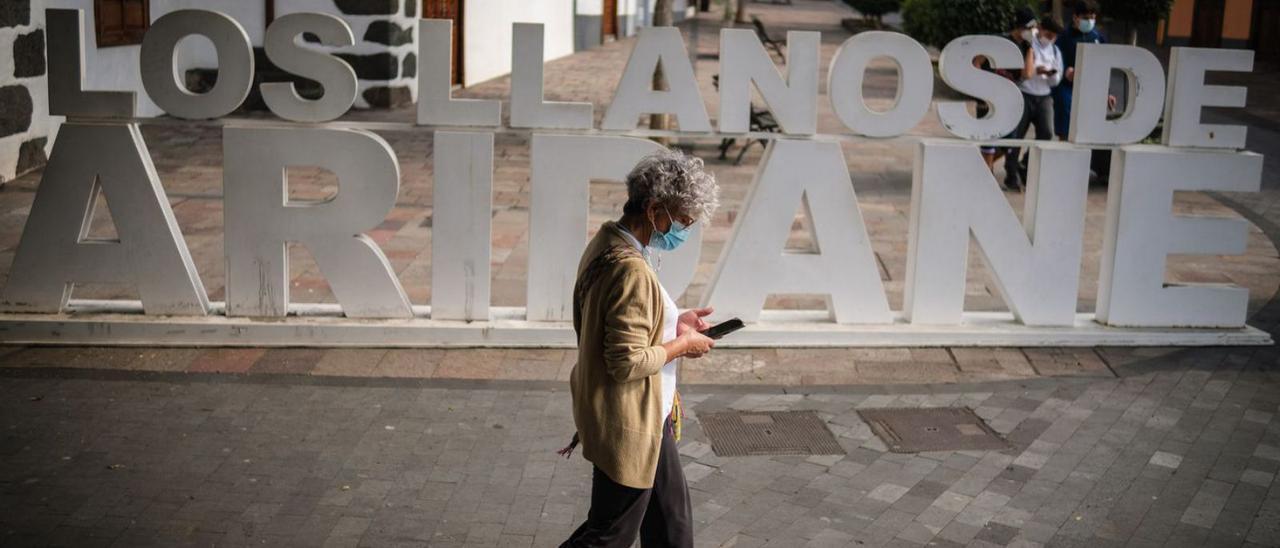 Una mujer atraviesa una céntrica calle del municipio de Los Llanos de Aridane.