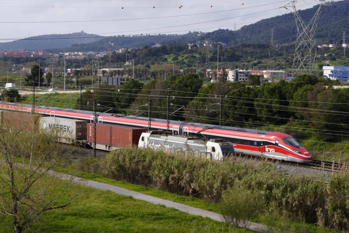Un tren de alta velocidad de la operadora Iryo se cruza con uno de mercancías a la altura de sant Vicenç dels Horts.