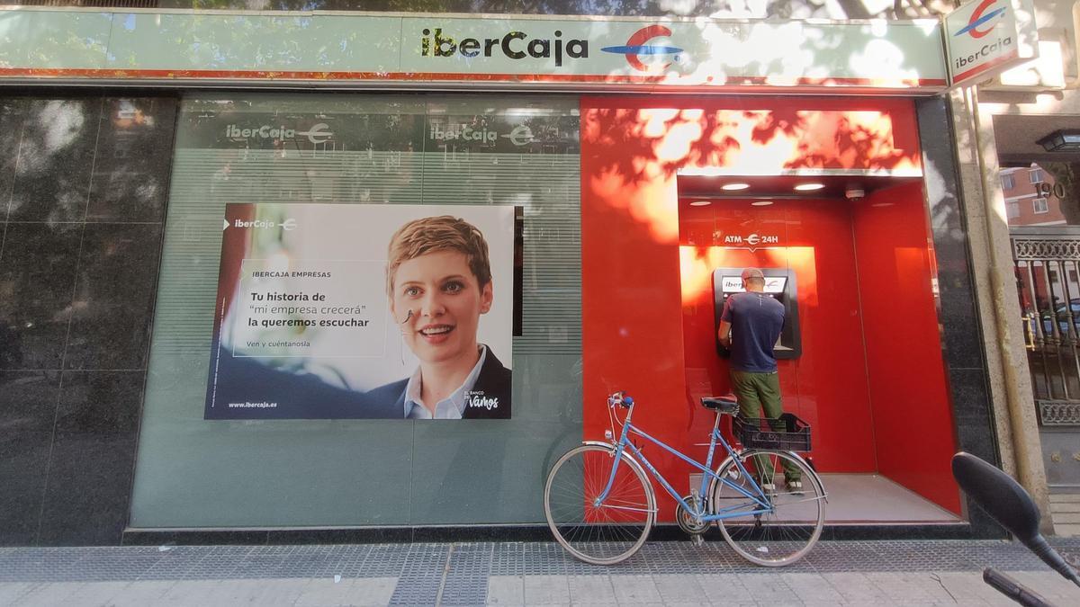Un hombre opera con su cuenta bancaria en una oficina de Ibercaja, en Zaragoza, ayer.