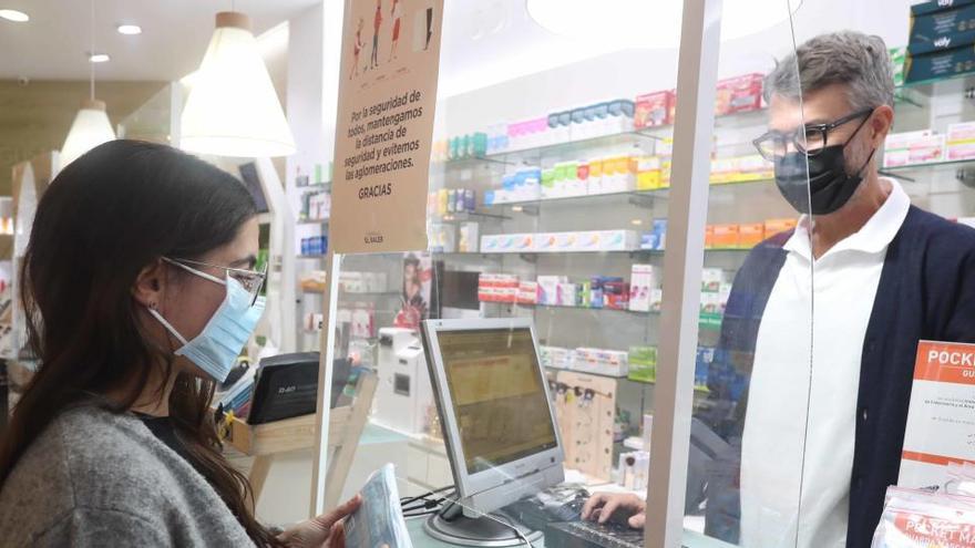 Una mujer compra mascarillas en una farmacia.