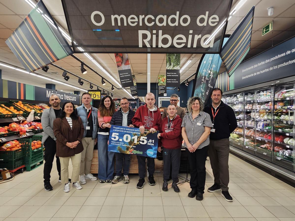 Asistentes al acto de entrega del cheque solidario en Ribeira