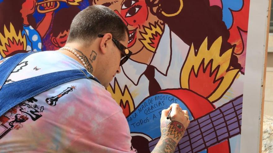 Ricardo Cavolo, ayer en Cartagena, firmando un cartel de La Mar de Músicas.