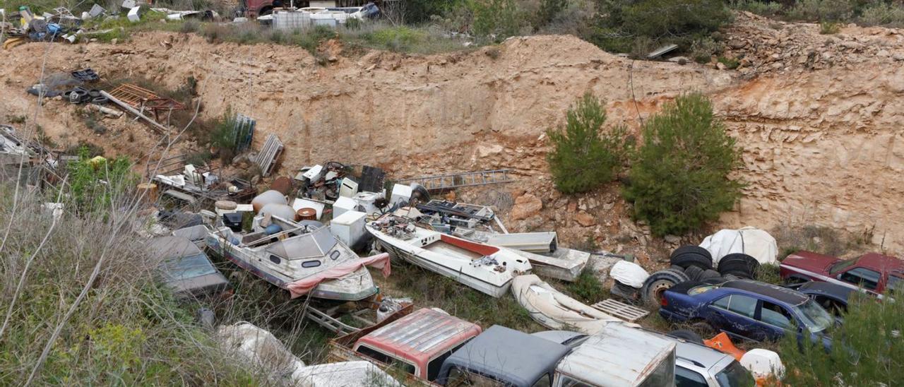 El desguace ilegal acumula docenas de embarcaciones y vehículos junto a un bosque. | J.A.RIERA