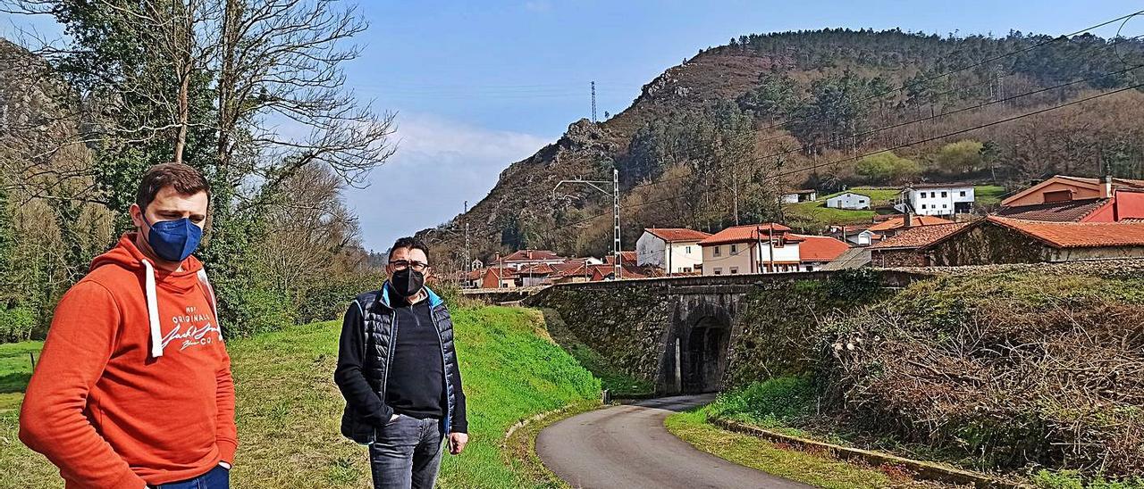 Carlos Fernandes y Chema López, de la Asociación Vecinal y Cultural Peñaflor, ayer, sobre el caballón que será ampliado y elevado, con la localidad al fondo. | S. Arias