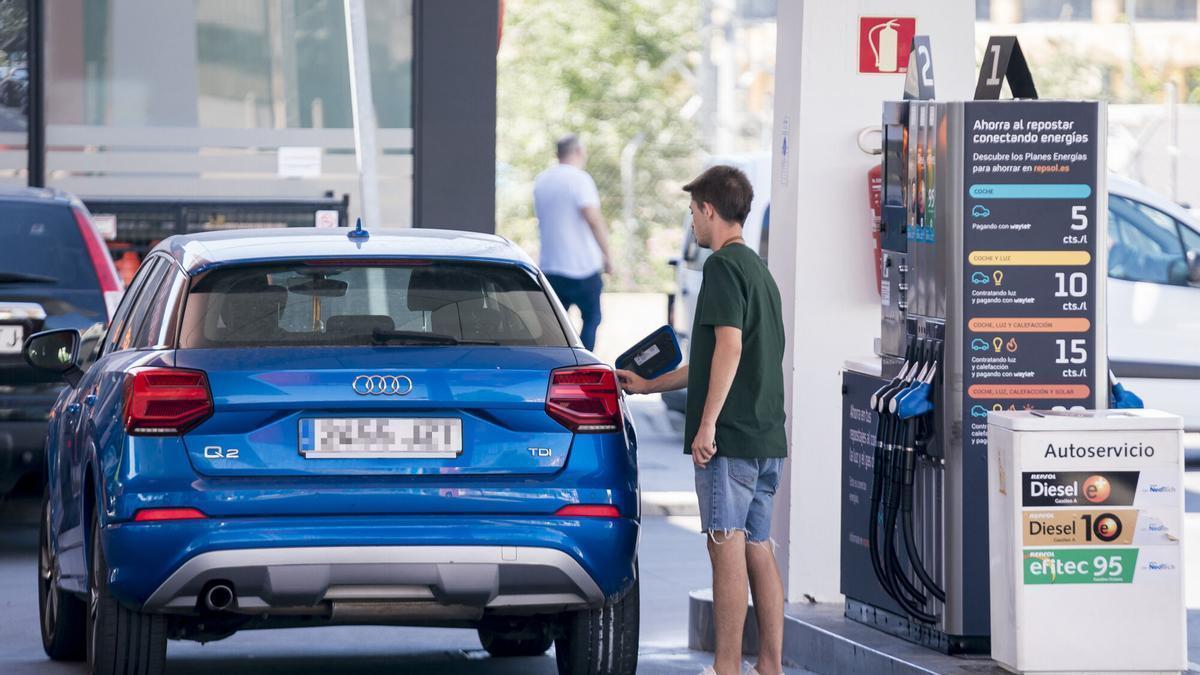 Una persona reposta en una gasolinera.
