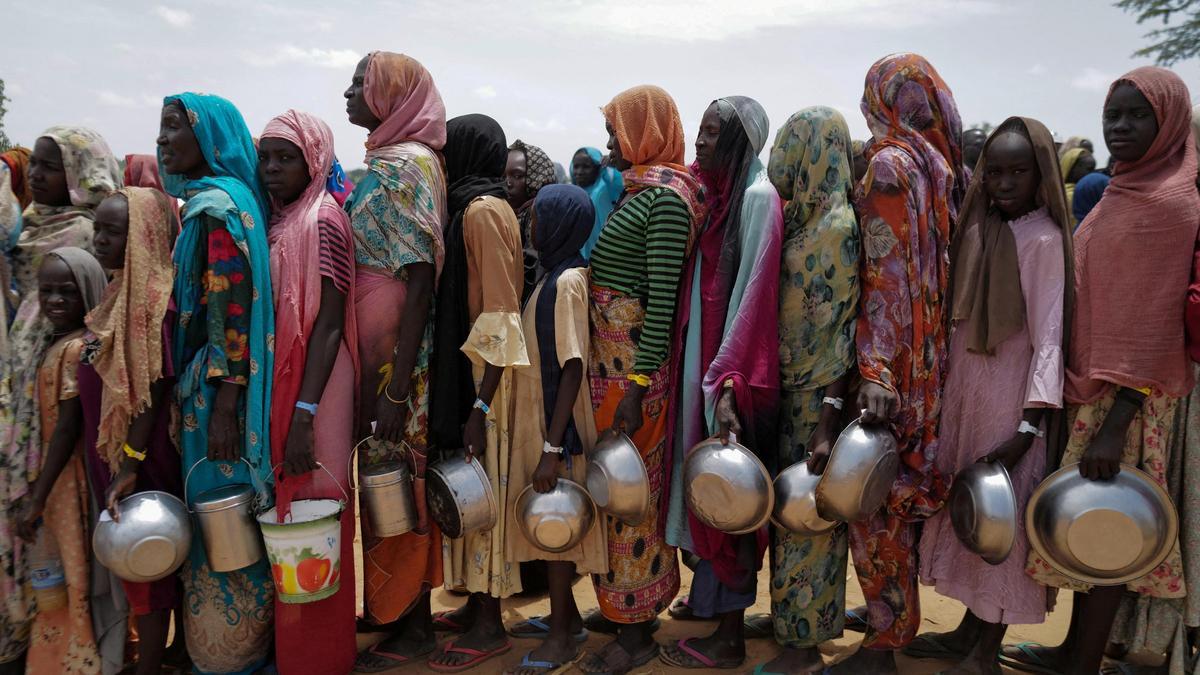 Mujeres sudanesas esperan para recibir arroz en Chad, tras huir de Sudán