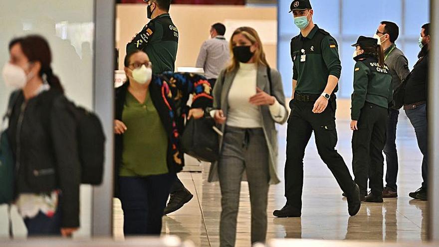 Personas con mascarilla en el aeropuerto de Barajas.   | // FERNANDO VILLAR