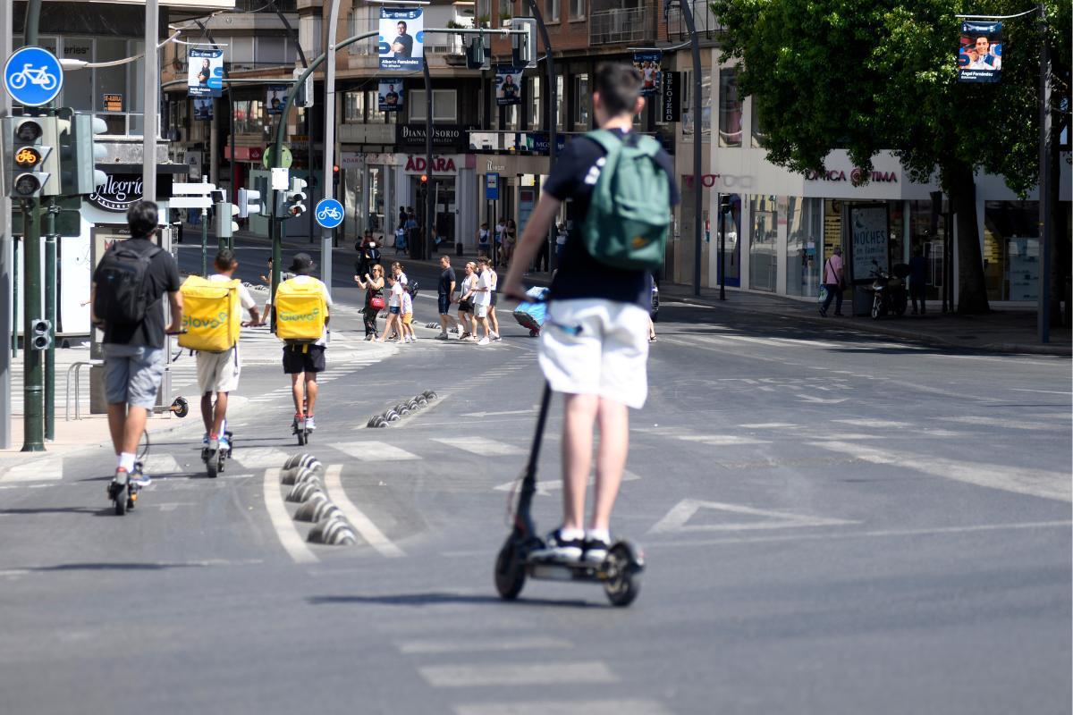 Varios usuarios de patinetes circulan por Murcia.