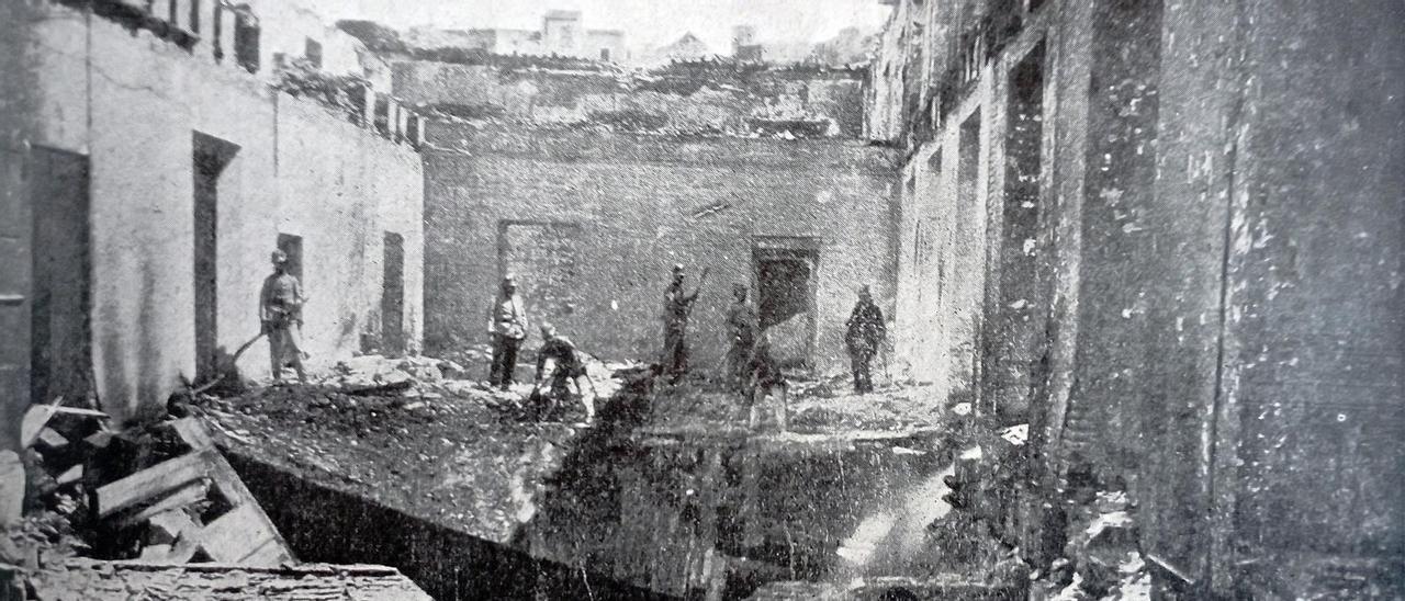 Un grupo de soldados retira los escombros del techo del segundo piso del edificio, tras el incendio.