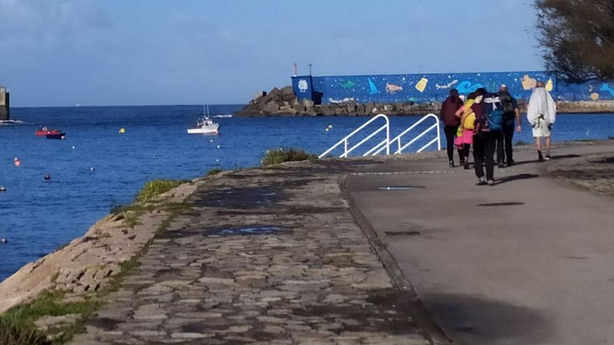 Peregrinos pasan por el puerto de A Guarda en su trayecto hacia Santiago.