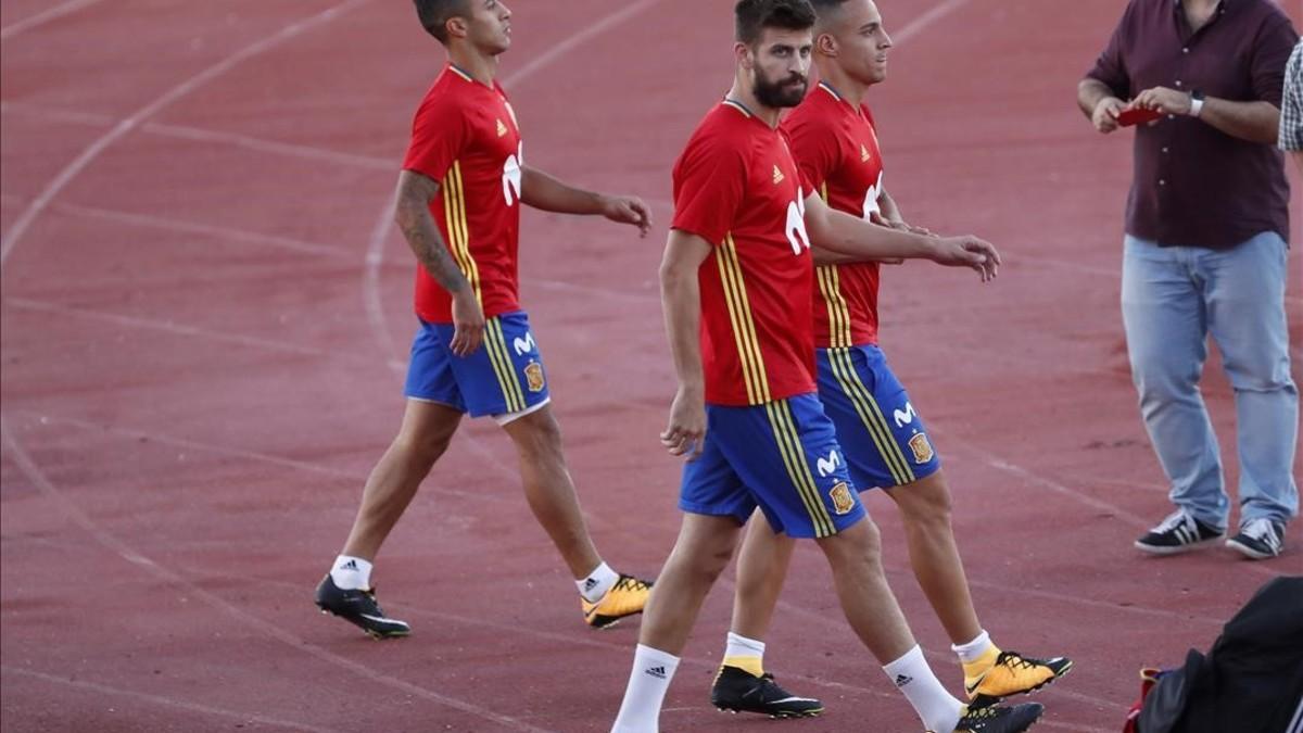 Thiago detrás de Piqué, en el entrenamiento del lunes en Las Rozas