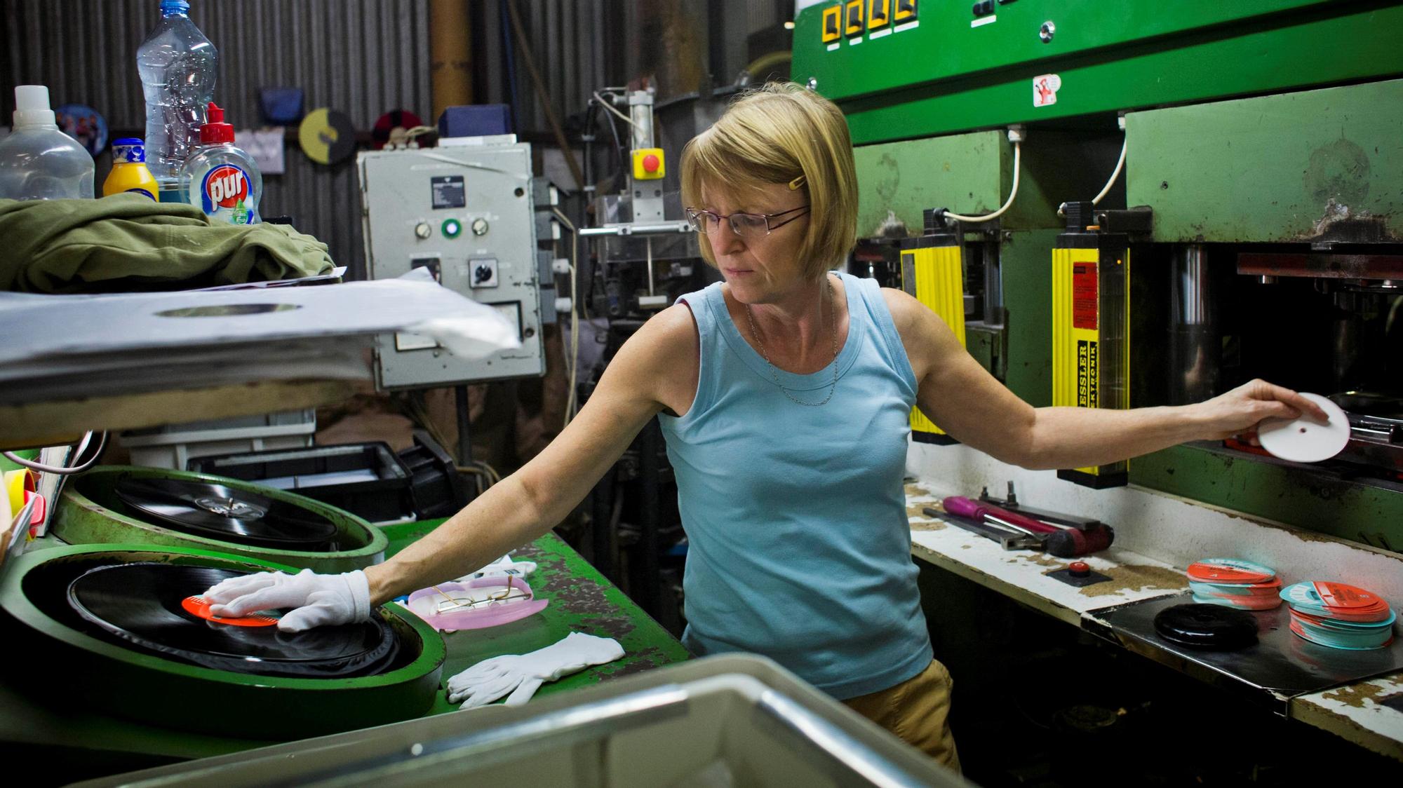 A worker operates machinery, as labels for 12&quot; inch vinyl records are 'pressed' together to form a vinyl record during the manufacturing process by GZ Media a.s. at their plant in Lodenice, Czech Republic, on Tuesday, Nov. 25, 2014. With about 10 million records made in 2013, GZ Media says it is the world's biggest vinyl record producer, making records for Universal Music Group, Sony Music and Warner Music. Photographer: Martin Divisek/Bloomberg via Getty Images