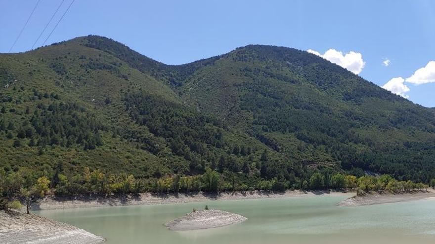 Situación del embalse de Arguis, en Huesca, este verano, varios metros por debajo de su nivel habitual.