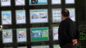 Un hombre observa los carteles de una inmobiliaria