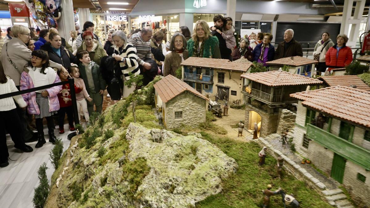 Elvira Suárez y Mari Paz Álvarez, en el centro, junto a asistentes a la inauguración del belén en Los Fresnos.