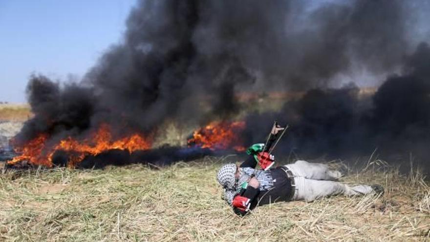 Un jove palestí llança pedres als soldats israelians durant la protesta a Gaza