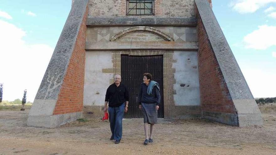 Dos personas ante las puertas del santuario ermita del Agavanzal en Olleros de Tera.