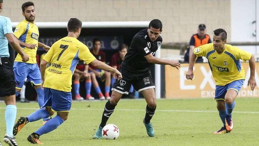 Medori, con la pelota, rodeado de varios jugadores del Real Unión -entre ellos Llamas, de espaldas-, ayer, en un momento del partido en Les Caleyes.