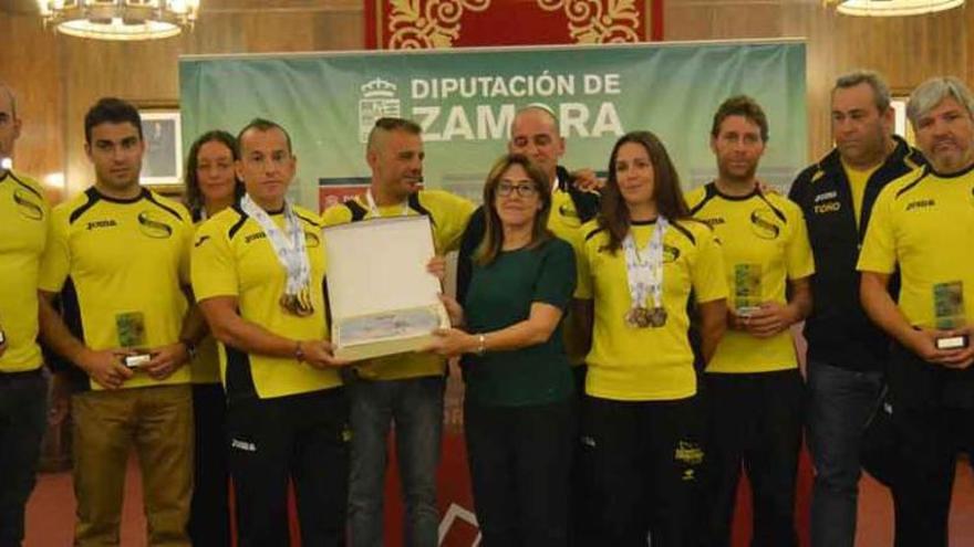 La presidenta de la Diputación entrega una placa al equipo.