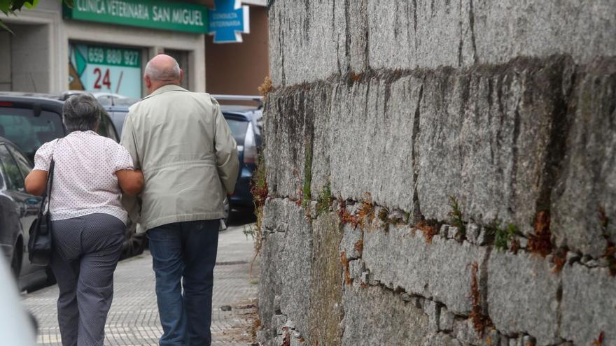 Una pareja de jubilados aprovecha la mañana del domingo para pasear por el centro de Ribadumia. |   // IÑAKI ABELLA