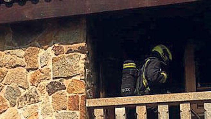 Uno de los bomberos ayer en la vivienda de Padróns. // D.P.