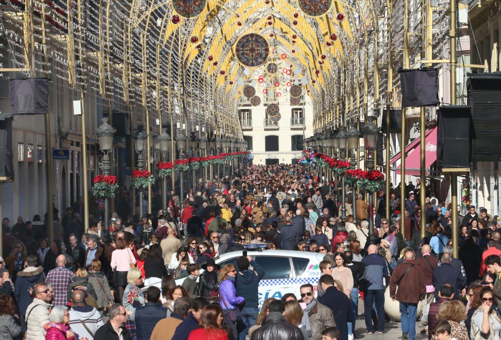 Muchos malagueños y turistas aprovechan el buen tiempo y el día festivo por la Inmaculada Concepción para pasear y realizar las compras navideñas en el Centro de Málaga.