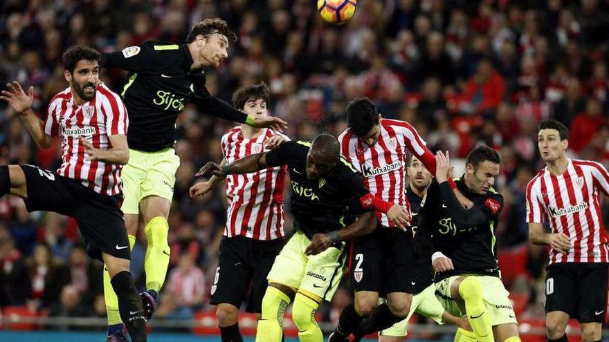 Raúl García golpea el balón y Amorebieta salta a su lado para despejarlo.