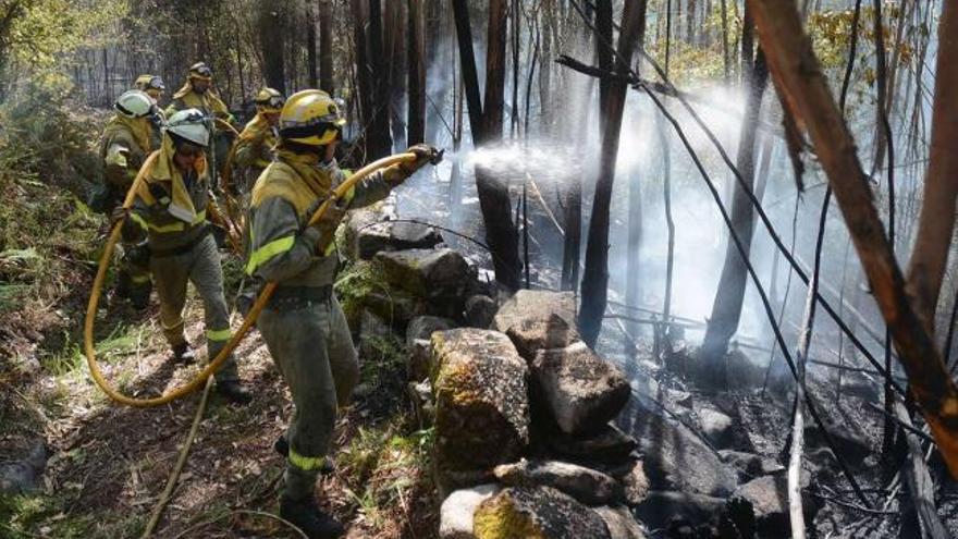 Una brigada intenta sofocar una zona del incendio forestal en Tenorio, Cotobade, ocurrido el pasado martes.  // Rafa Vázquez