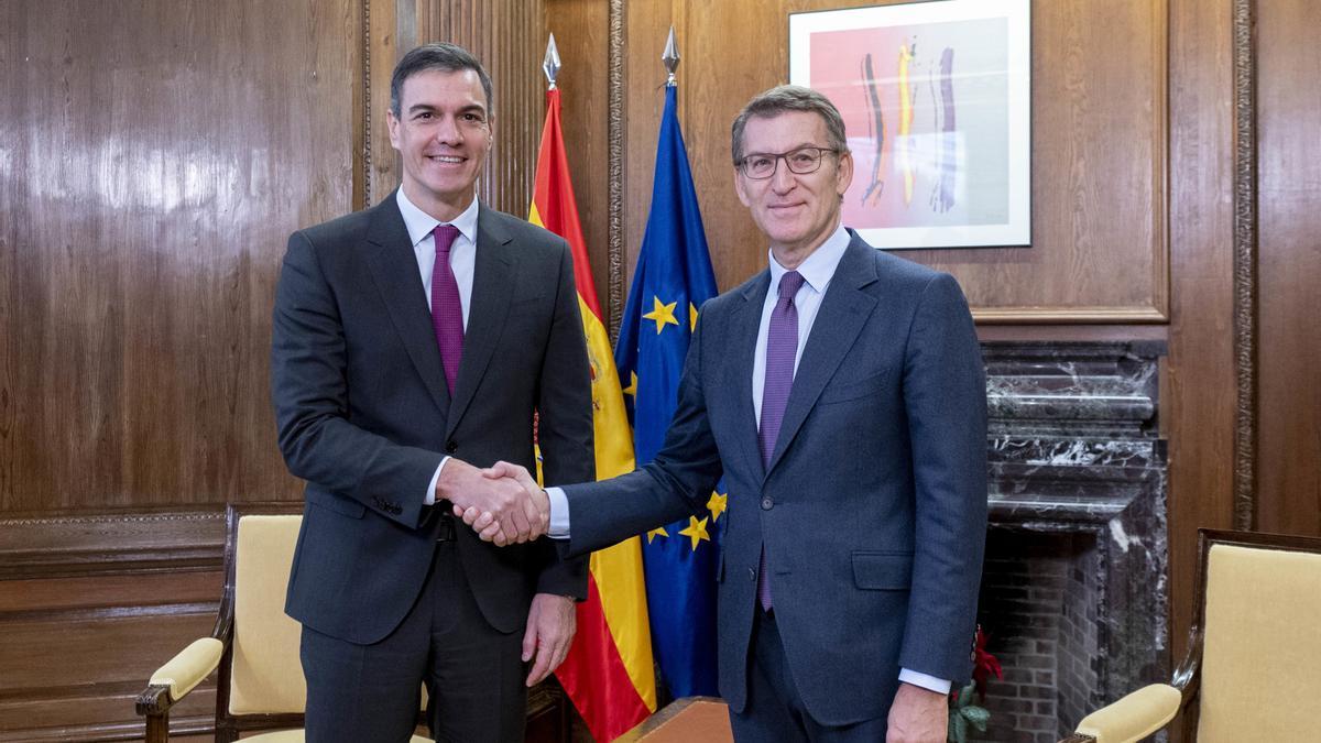 El presidente del Gobierno, Pedro Sánchez (i), y el líder del PP, Alberto Núñez Feijóo (d), se saludan durante una reunión, en el Congreso de los Diputados, a 22 de diciembre de 2023, en Madrid (España).