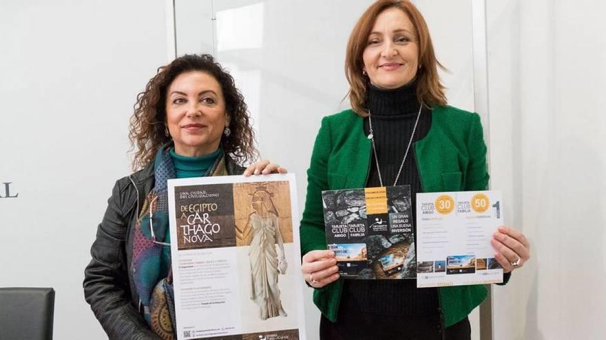 Obdulia Gómez (i.) y Agustina Martínez posan con los carteles promocionales de las actividades.