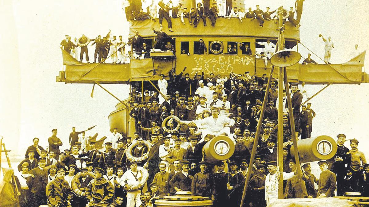 La dotación del acorazado Alfonso XIII posa en la proa del buque con el número agraciado pintado