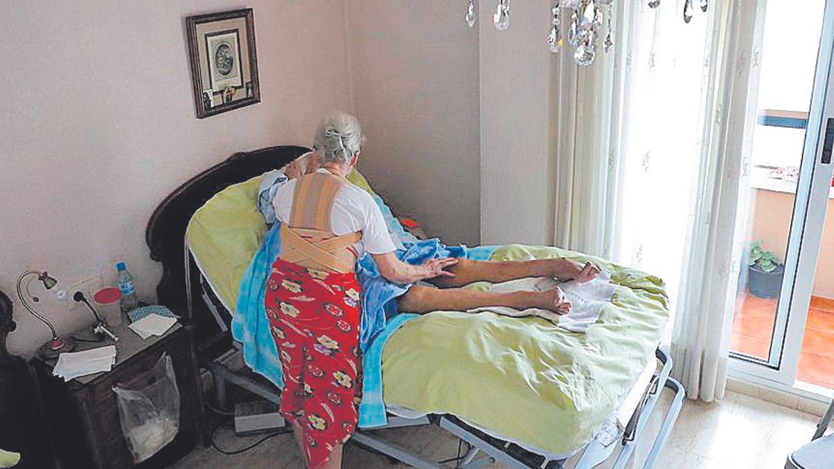Una señora de más de 70 años tiene que cuidar a su tia de 92 años, muy enferma y en cama, en imagen de archivo.