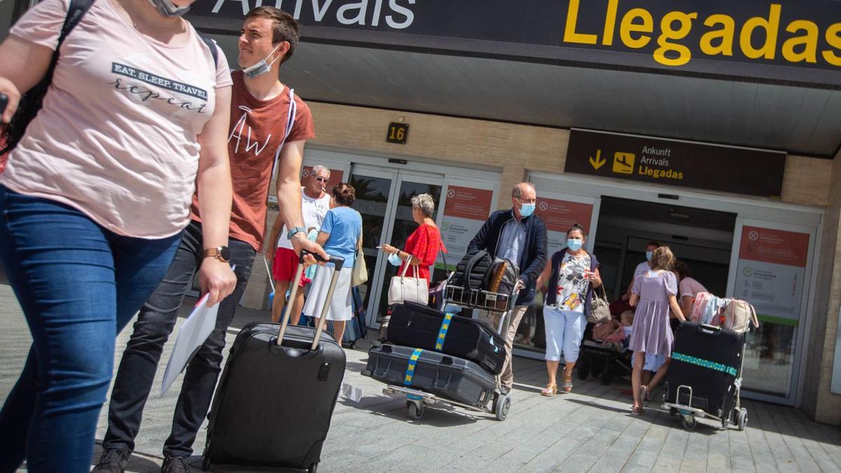 Turistas británicos salen de la terminal de llegadas del aeropuerto de Tenerife Sur. | | CARSTEN W. LAURITSEN