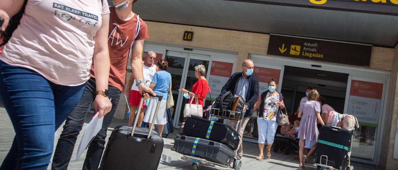 Turistas británicos salen de la terminal de llegadas del aeropuerto de Tenerife Sur. | | CARSTEN W. LAURITSEN