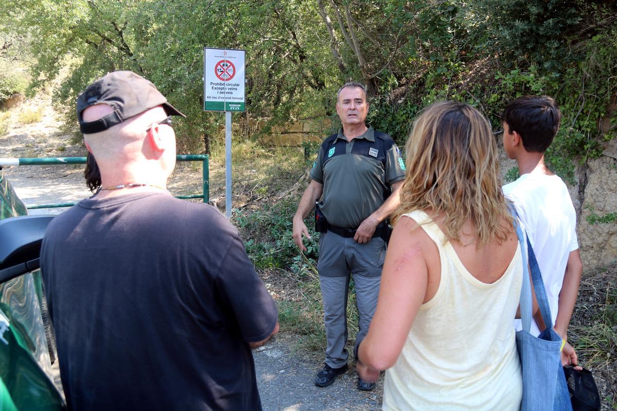 Un Agent Rural informa una família sobre el tancament de l'accés al Montsec a la zona de Corçà, a Àger, per l'activació del pla Alfa 3