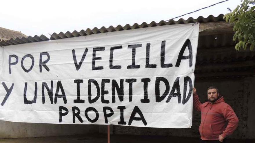 César Mayo, vecino del pueblo, con la pancarta reivindicativa