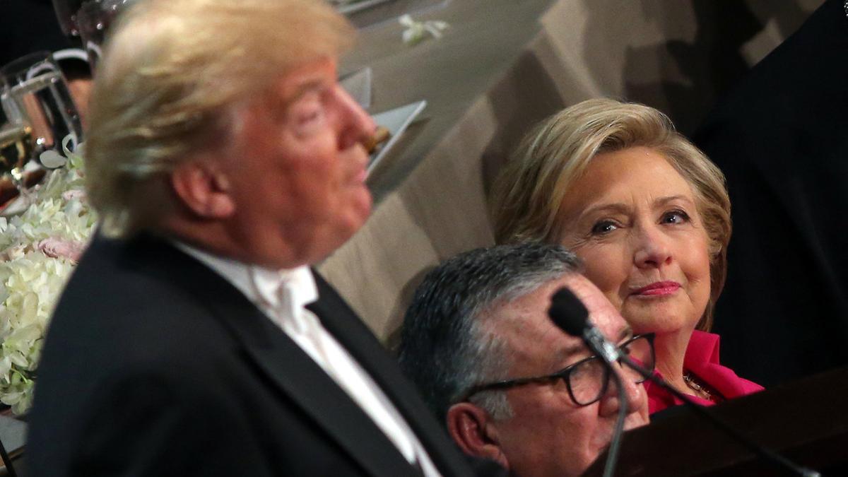 Clinton, sentada junto al obispo de Nueva York, observa a Trump durante su intervención en la cena benéfica del jueves.
