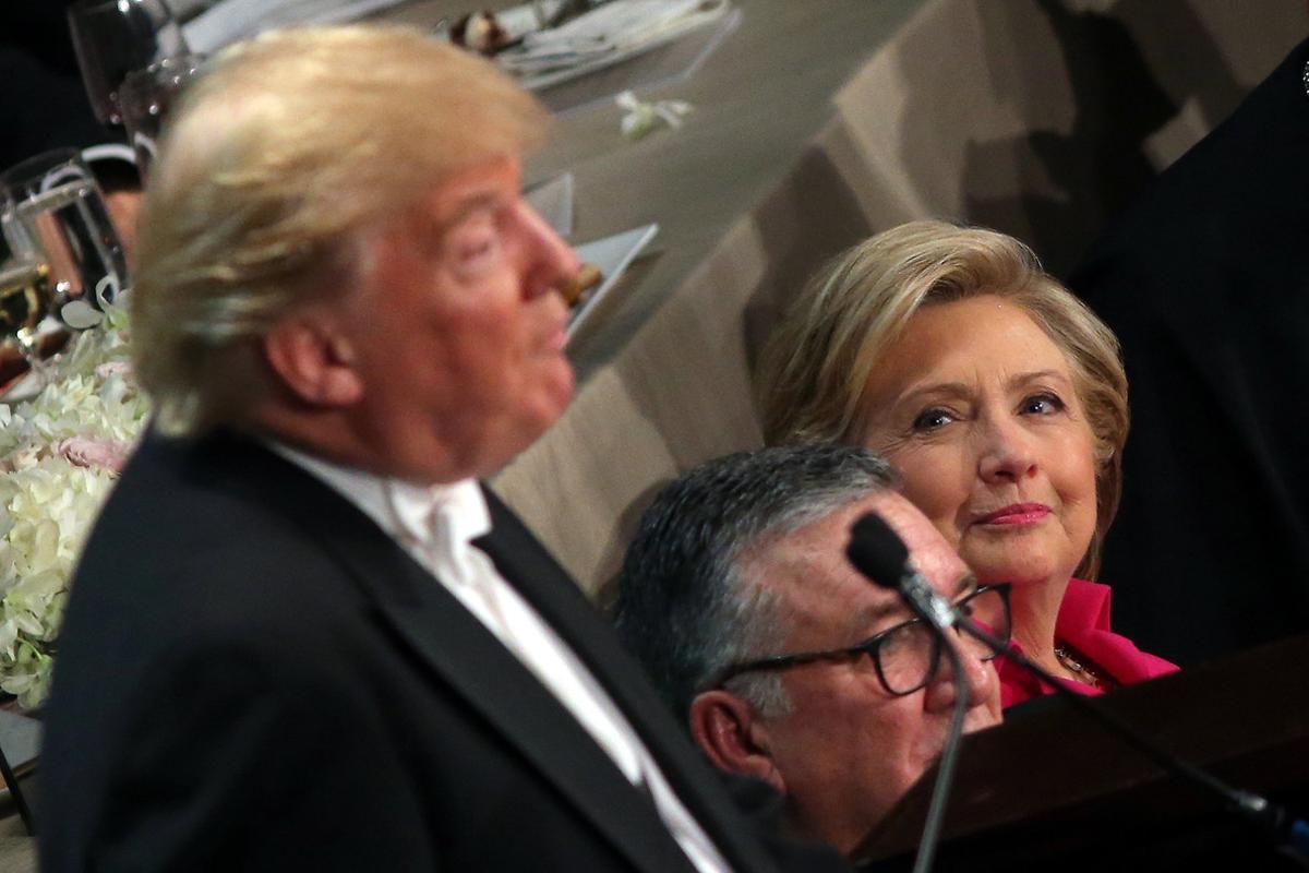 Clinton, asseguda al costat del bisbe de Nova York, observa Trump durant la seva intervenció en el sopar benèfic de dijous.