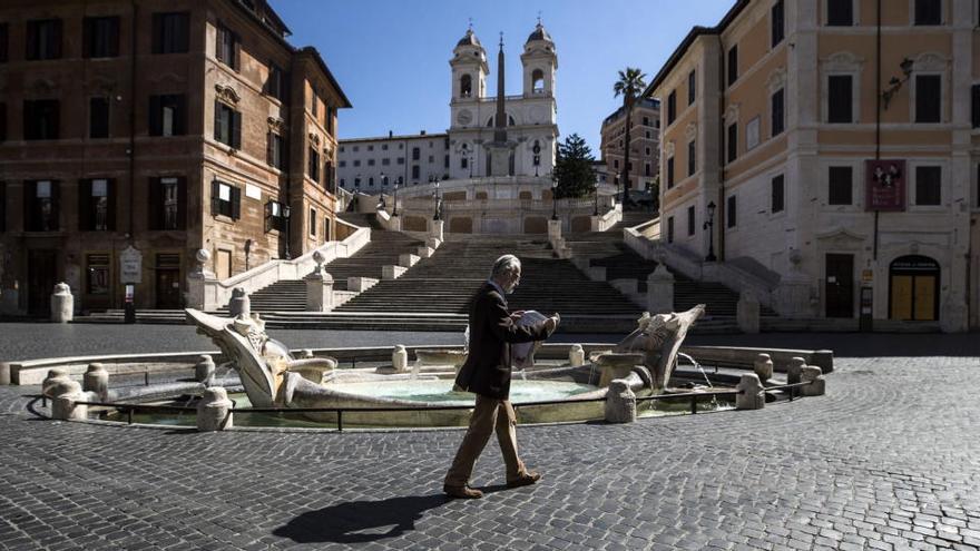 Un hombre cruza la plaza de España, en Roma.