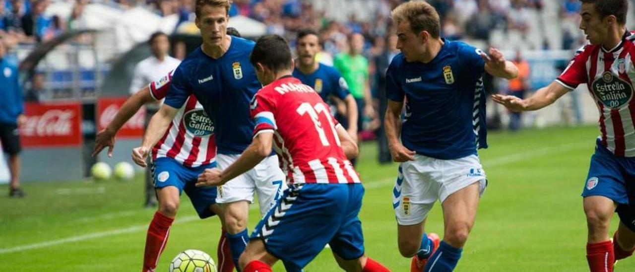 Susaeta, con el balón, presionado por Manu, con Héctor Font a la derecha.