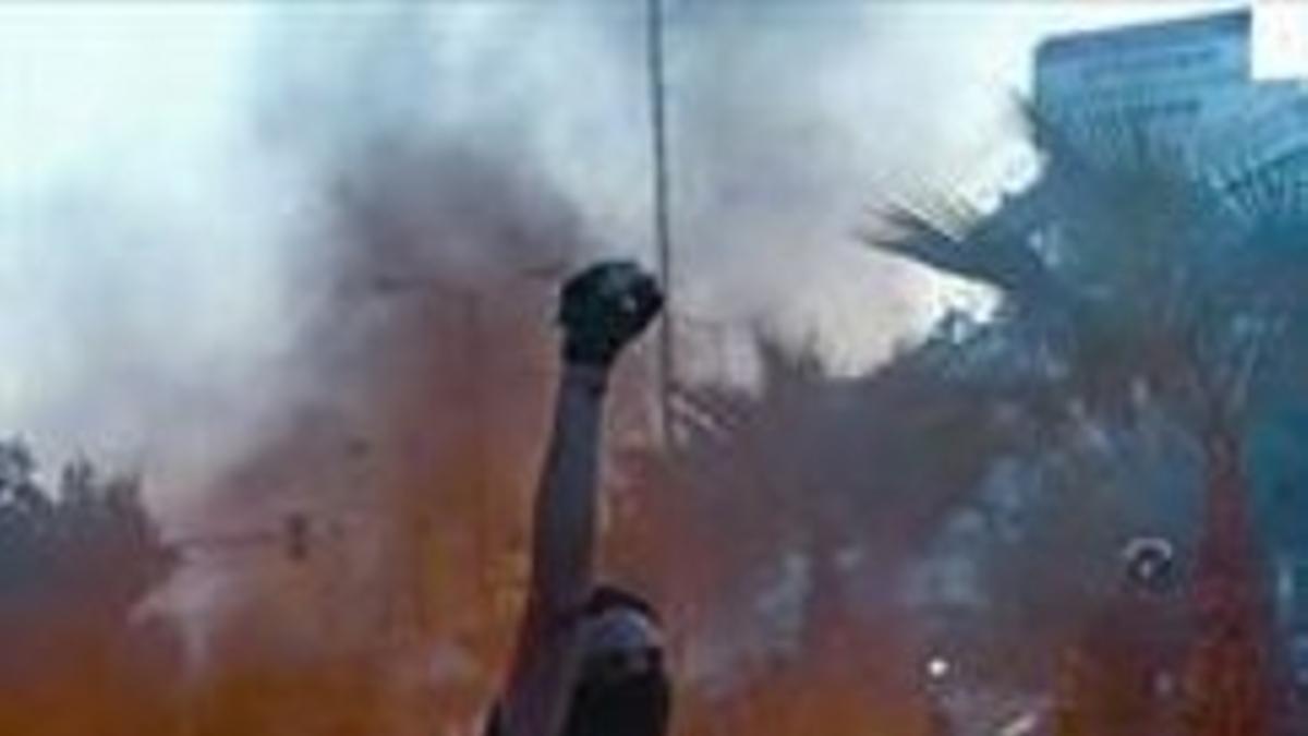 Un manifestante alza el puño en los disturbios de anoche en Atenas.