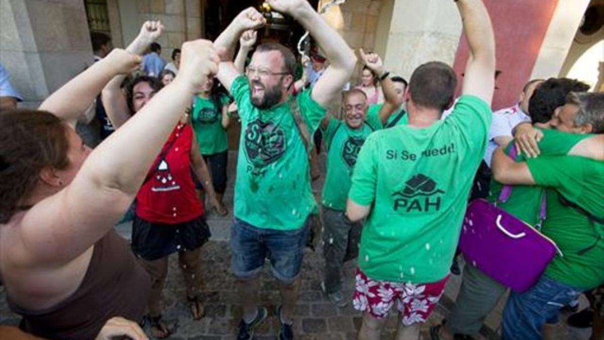 Carlos Macías, portavoz de la PAH, es rociado con cava a la salida del Parlament, ayer tras la aprobación de la ILP de la vivienda.