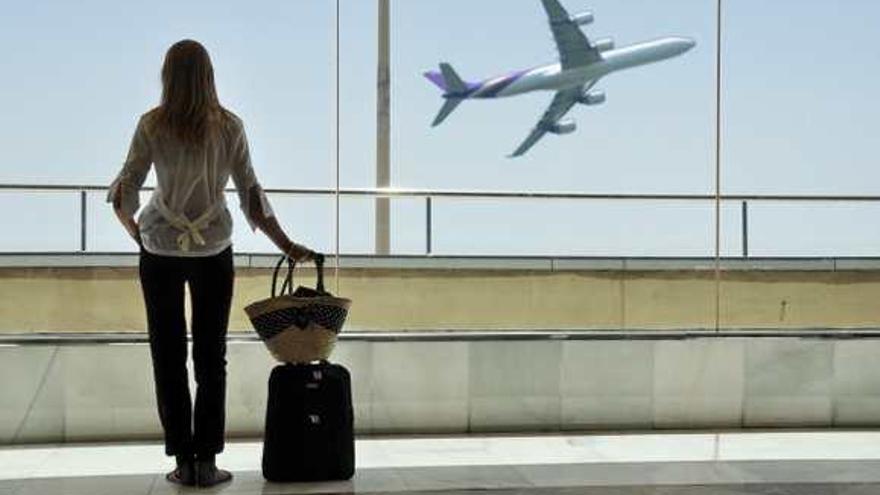 Una joven observando la salida de un avión en el aeropuerto.