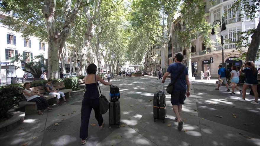 La imagen es de hace unos días, pero empezará a verse menos con la persecución del alquiler en pisos: turistas con maletas por el centro de Palma