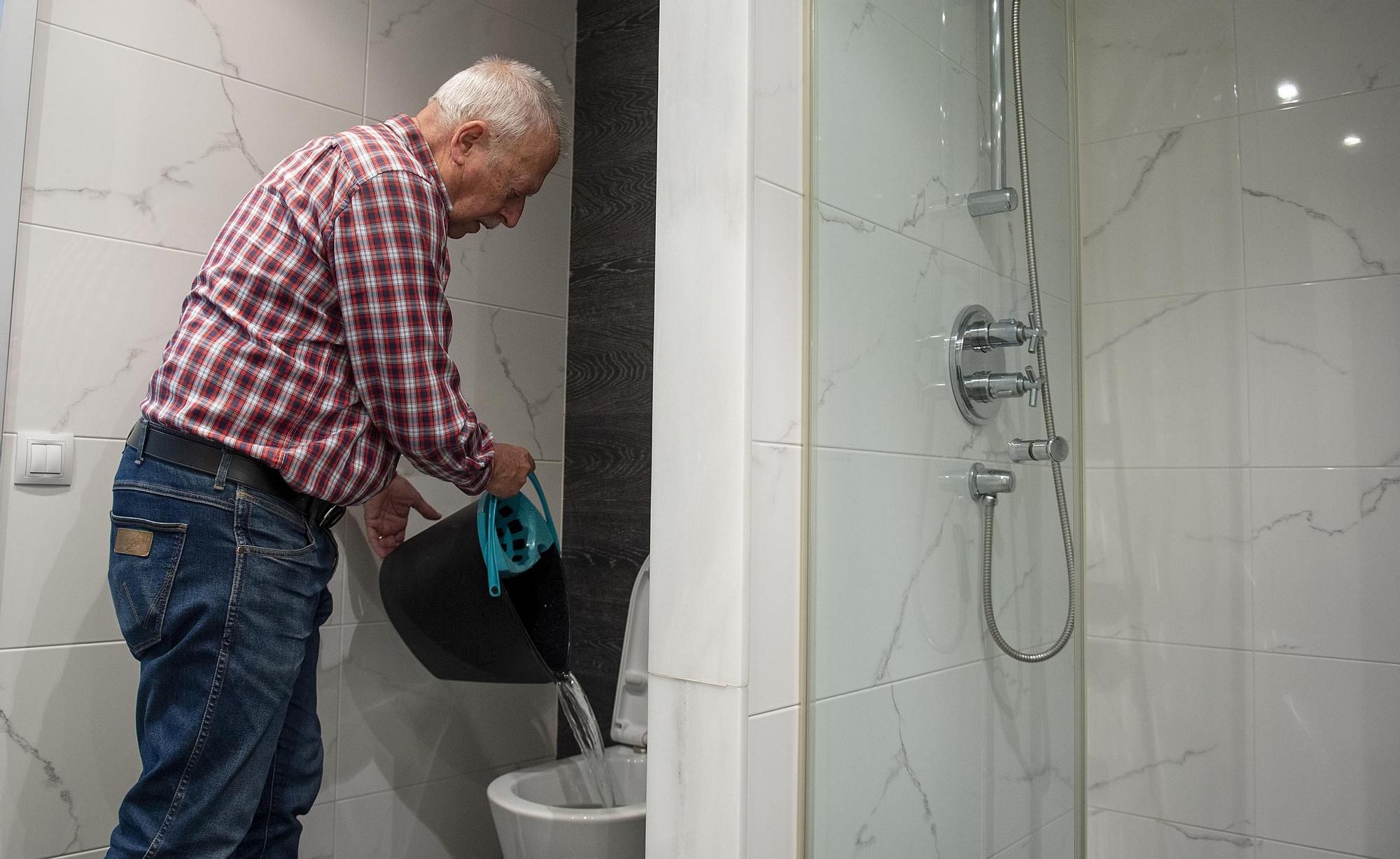 Víctor Palomera, vecino de Nou Barris, reutiliza el agua fría de la ducha que recoge en un cubo.