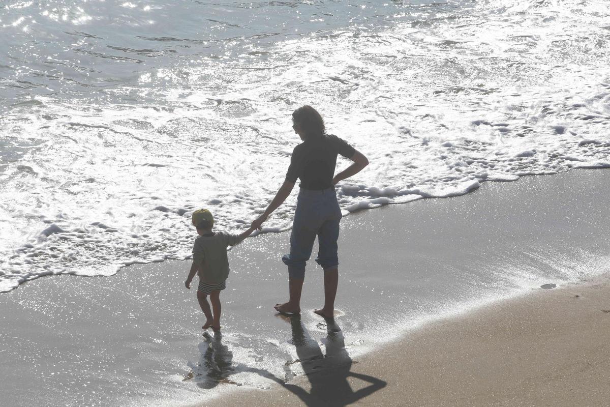 Una mujer y un niño en la playa de Riazor.