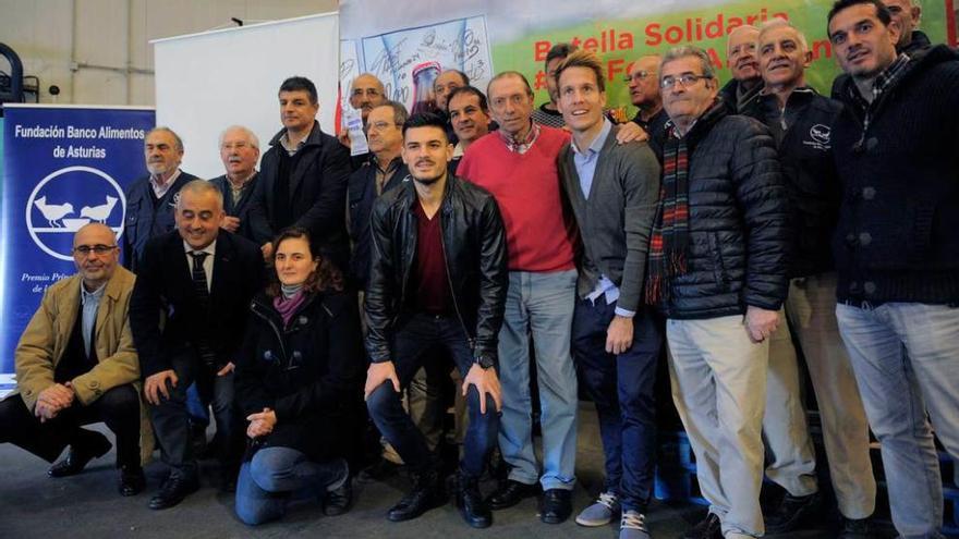 Los representantes del Oviedo y del Sporting, posando ayer con los voluntarios del Banco de Alimentos.