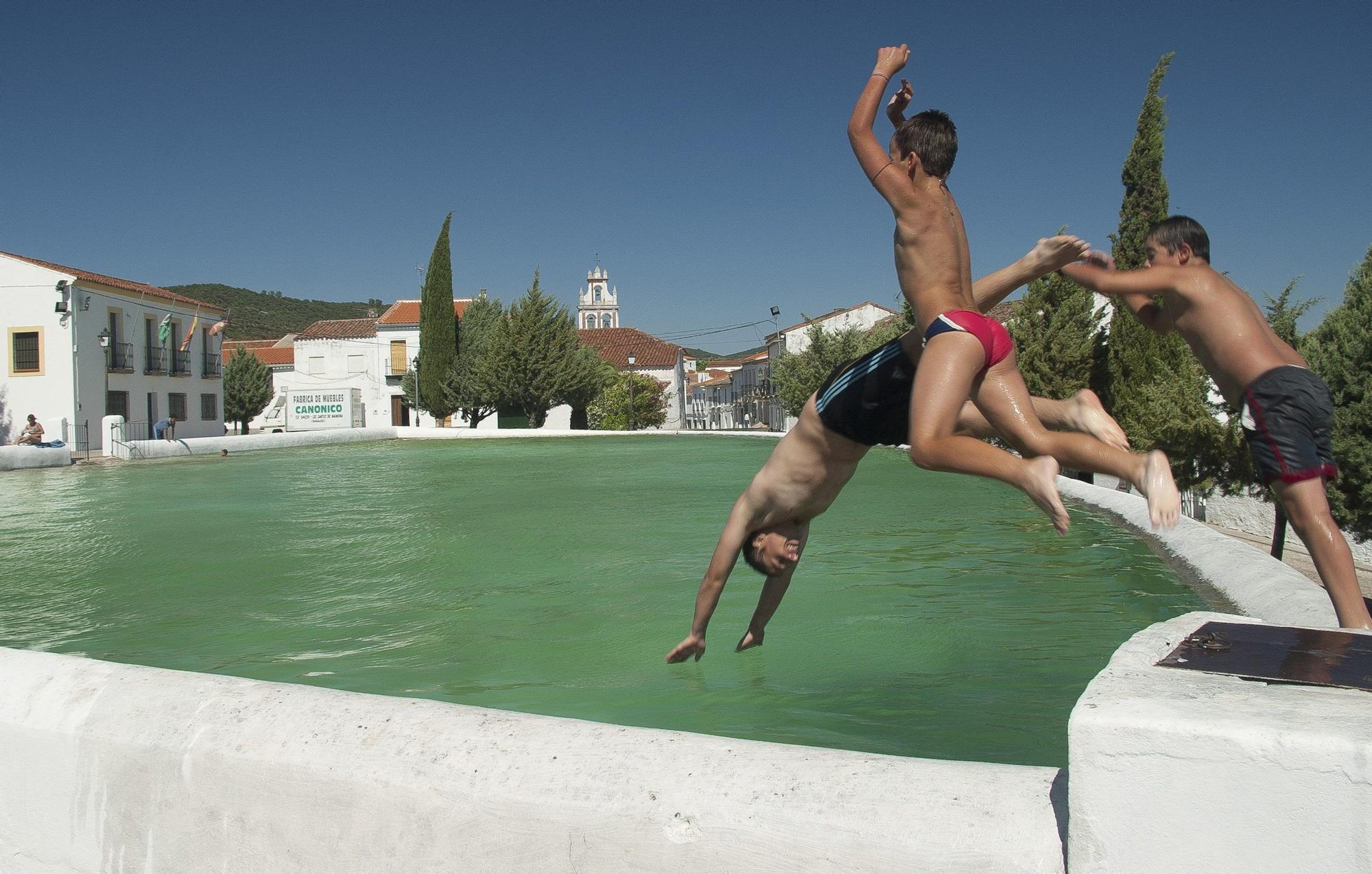 Unos niños se lanzan a una piscina.